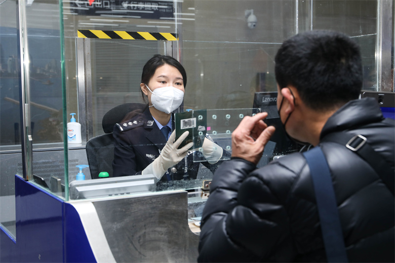 1月9日，山東出入境邊防檢查總站青島機場邊檢站民警為入境旅客辦理通關(guān)手續(xù)。解豪攝