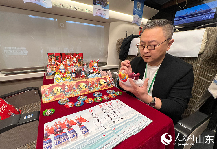 圖2）濟南車廂內(nèi)非遺傳承人楊峰現(xiàn)場制作手工藝品《泉城兔子王》。人民網(wǎng) 劉祺攝