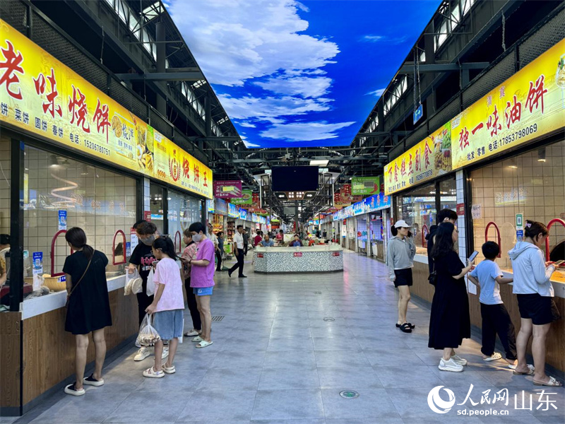 麷街市集內(nèi)消費(fèi)者正在購(gòu)買食品。人民網(wǎng) 鄭昕橋攝
