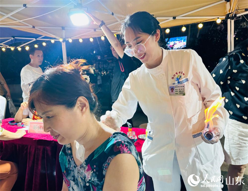 濰坊市民在中醫(yī)藥文化夜市上體驗火龍罐。人民網 喬姝攝