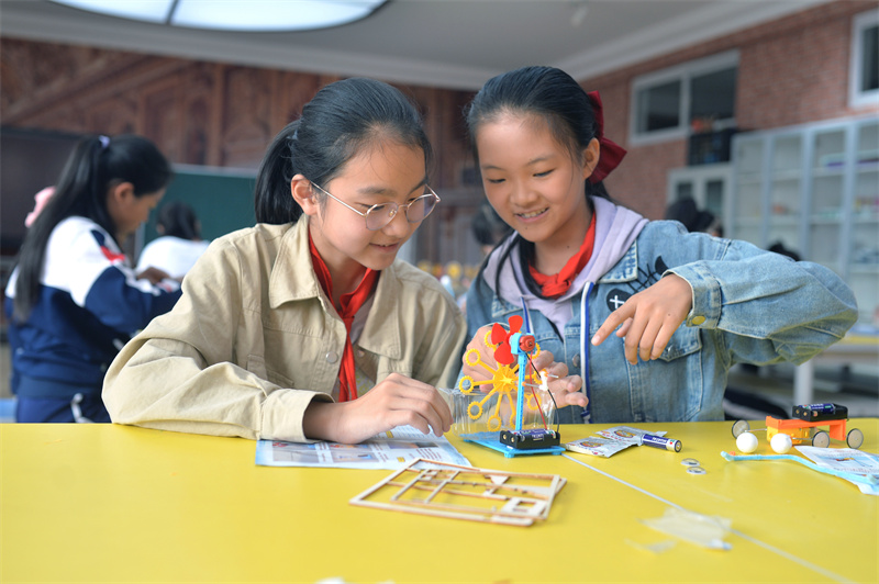 2024年10月10日，在山東青島普新小學(xué)的手工課堂上，兩名學(xué)生在安裝制作泡泡機(jī)。