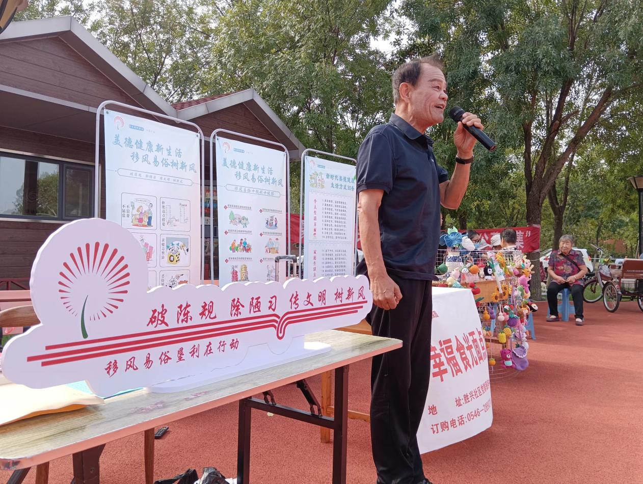 東營市墾利區(qū)勝興社區(qū)睦鄰廣場上，戲曲愛好者李景成將移風(fēng)易俗改編成戲曲，現(xiàn)場觀眾獻上陣陣掌聲。