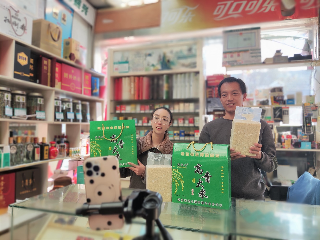 圖為劉路路和客戶(hù)經(jīng)理直播銷(xiāo)售大米