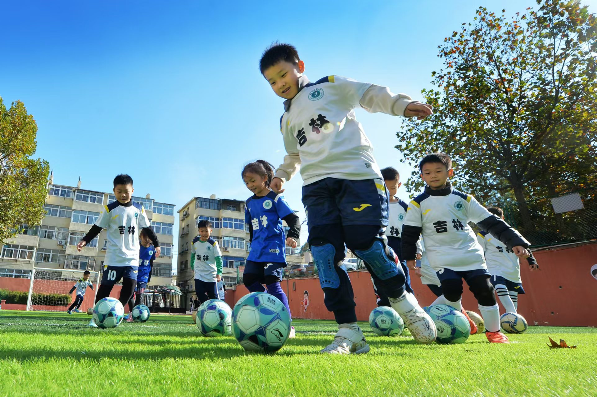 2024年11月18日，在山東青島吉林路小學(xué)開展的足球冬訓(xùn)活動上，孩子們在綠茵場上進行帶球訓(xùn)練。