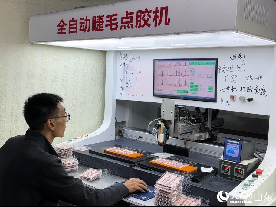 技術(shù)人員正在操作全自動睫毛點膠機。人民網(wǎng) 喬姝攝