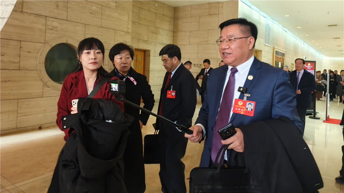 1月19日，山東省政協(xié)十三屆三次會(huì)議開幕，一位委員走出會(huì)場(chǎng)，邊走邊接受采訪。人民網(wǎng)記者宋翠攝