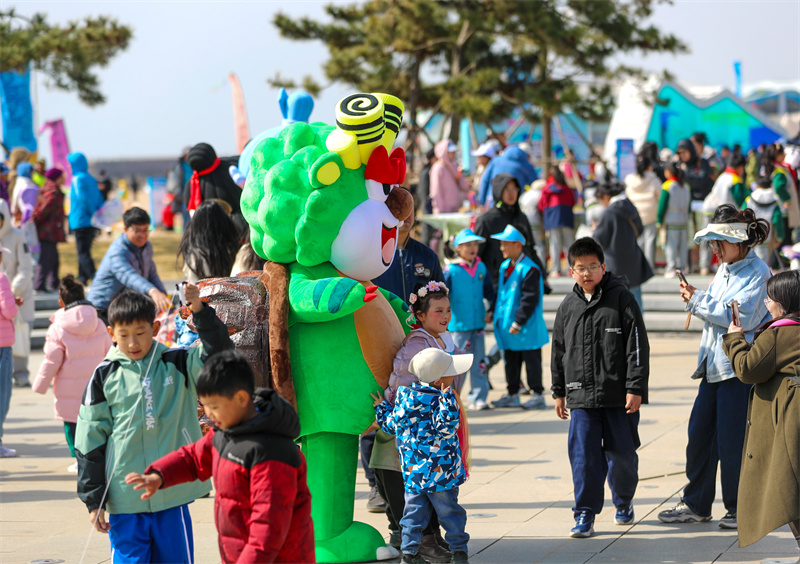 3月29日，在山東青島嶗山區(qū)石老人浴場，人們走出家門，享受春日。