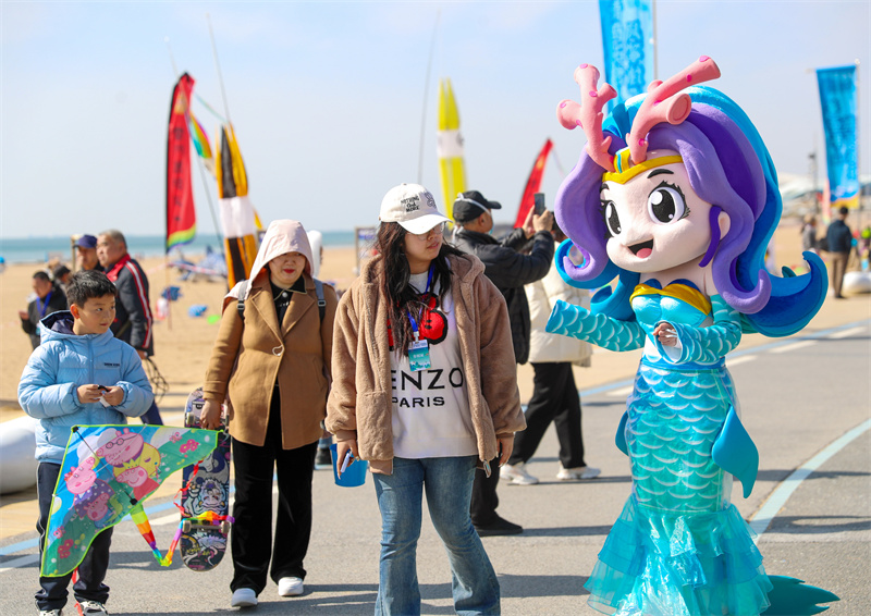 3月29日，在山東青島嶗山區(qū)石老人浴場，人們走出家門，享受春日。