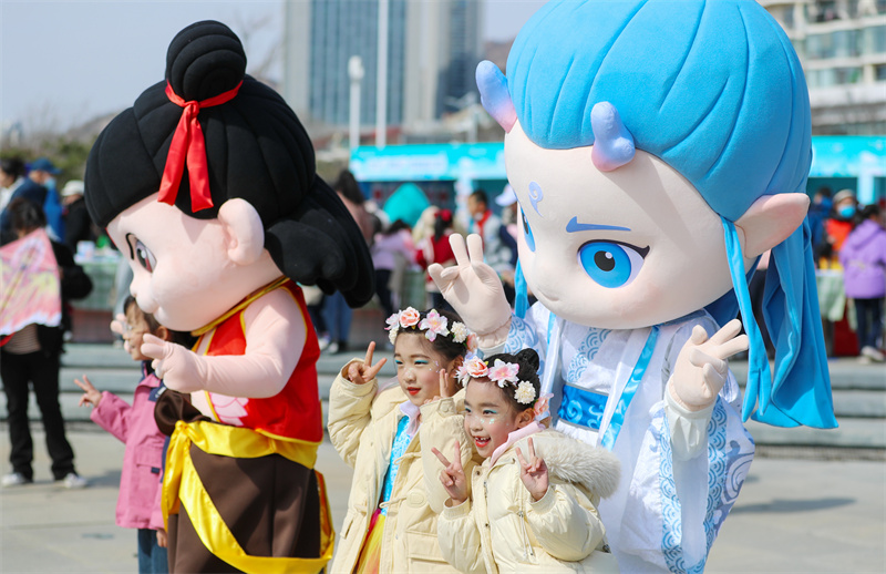 3月29日，在山東青島嶗山區(qū)石老人浴場，小朋友和“哪吒”“敖丙”互動拍照。