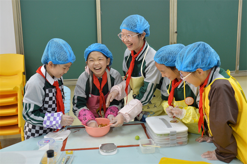 2025年4月2日，學生們在山東省青島市市北區(qū)普新小學開展的民俗迎清明活動上制作青團餡料。王海濱攝