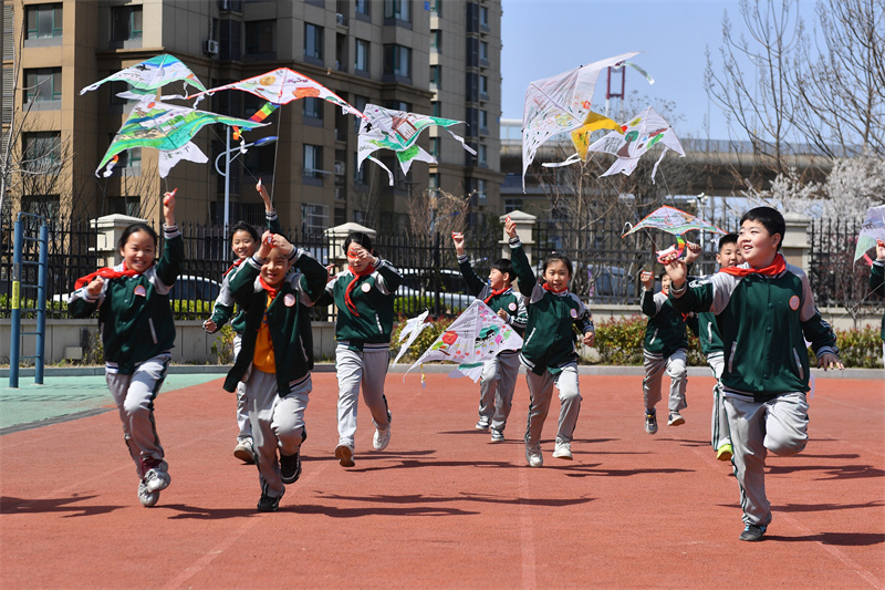 學生們在山東省青島市市北區(qū)普新小學開展的民俗迎清明活動上放飛自制的風箏。王海濱攝
