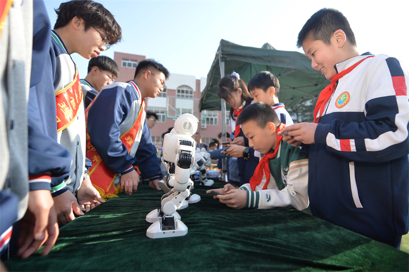 學(xué)生們?cè)隗w驗(yàn)舞蹈機(jī)器人。王海濱攝