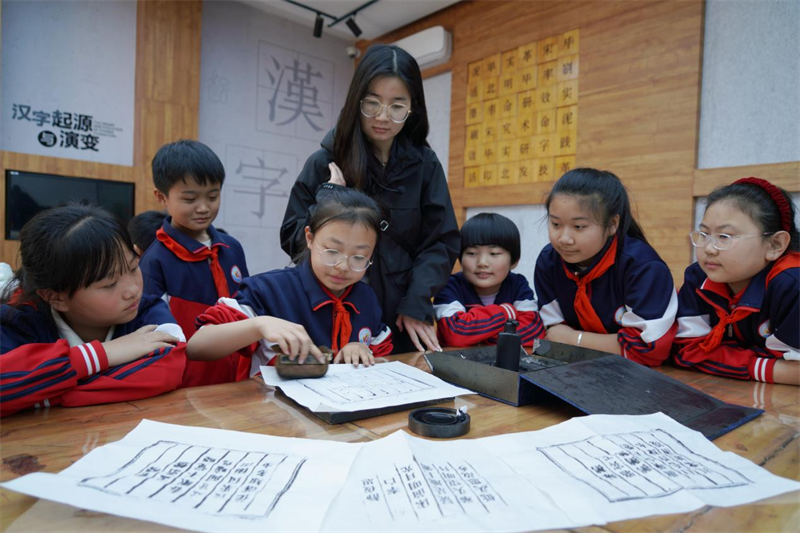 在山東省臨沂市沂南縣馬牧池鄉(xiāng)沂蒙紅色研學(xué)營地新華書香館，學(xué)生們正在用活字印刷設(shè)備進(jìn)行印刷。