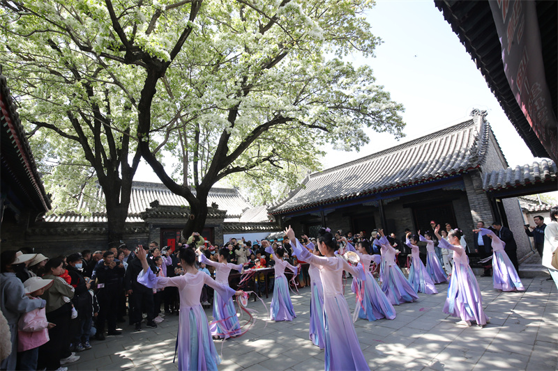 4月13日，在山東鄒城孟府景區(qū)，少年兒童在盛開(kāi)的流蘇花下表演舞蹈。