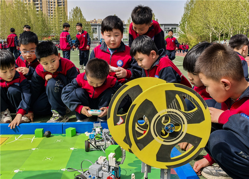 2025年4月16日，山東省樂(lè)陵市市中街道阜平小學(xué)科技勞動(dòng)周現(xiàn)場(chǎng)，小學(xué)生在通過(guò)無(wú)線指令遙控“機(jī)器人”做游戲。