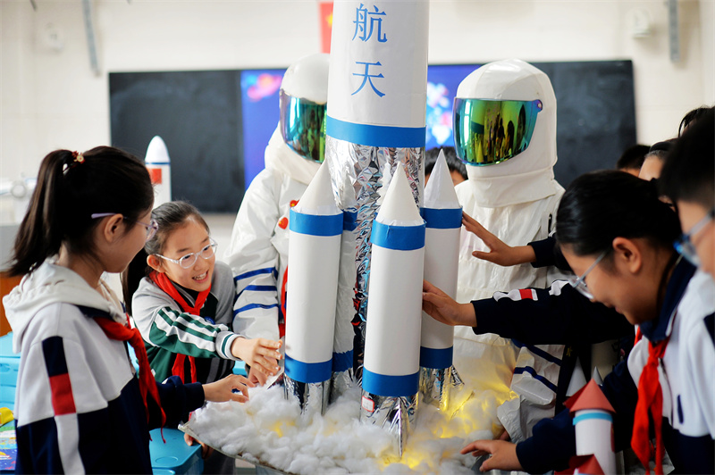 2025年4月24日，在山東省青島市市北區(qū)洛陽路第二小學(xué)開展的“中國航天日”科普活動上，學(xué)生們在擺放自制的運載火箭模型。