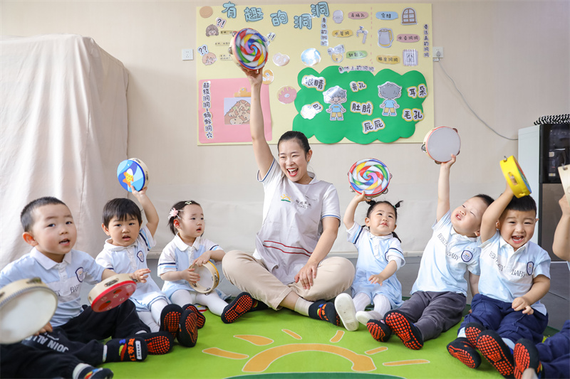 2025年5月14日，在山東省青島市李滄區(qū)職工子女愛心托育中心，老師帶領(lǐng)小朋友做游戲。張鷹 攝 
