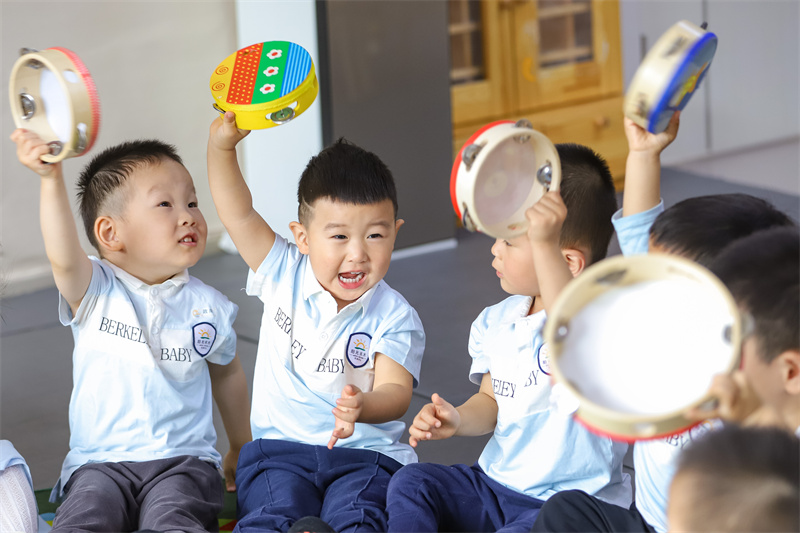 2025年5月14日，在山東省青島市李滄區(qū)職工子女愛心托育中心，老師帶領(lǐng)小朋友做游戲。張鷹 攝 