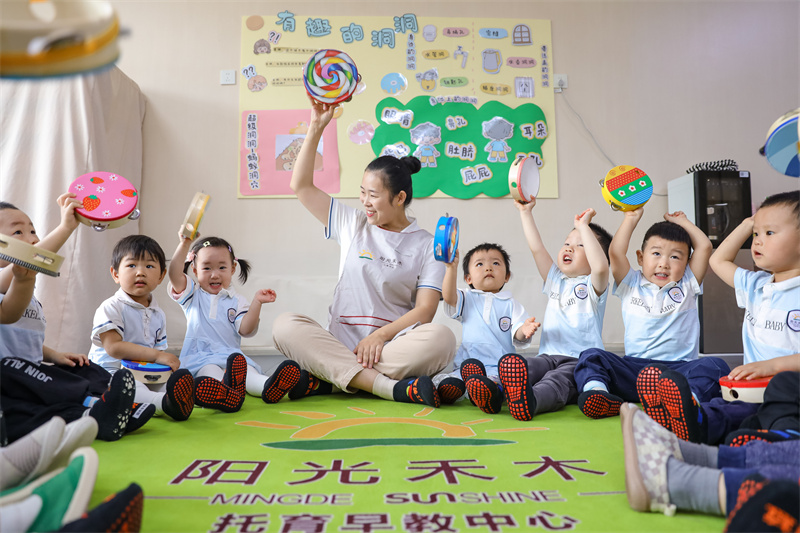 2025年5月14日，在山東省青島市李滄區(qū)職工子女愛心托育中心，老師帶領(lǐng)小朋友做游戲。張鷹 攝