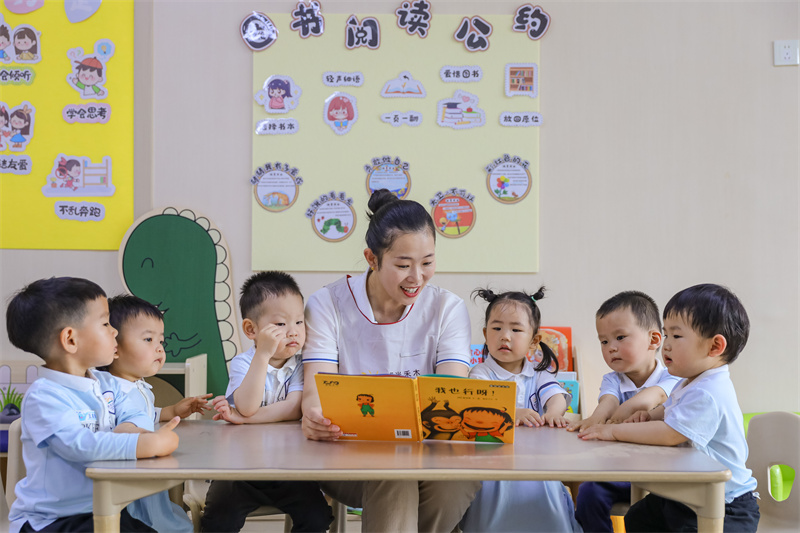 2025年5月14日，在山東省青島市李滄區(qū)職工子女愛心托育中心，老師為小朋友閱讀繪本。張鷹 攝