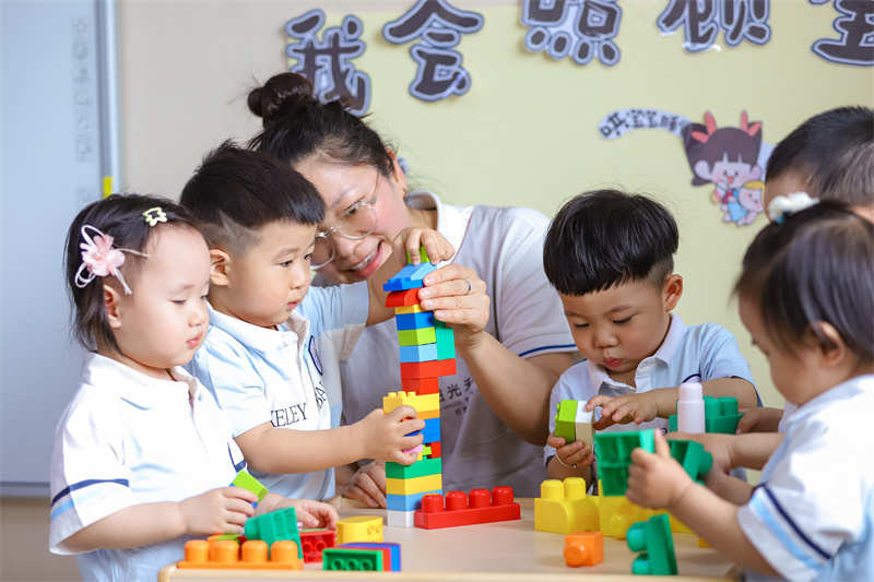 2025年5月14日，在山東省青島市李滄區(qū)職工子女愛心托育中心，小朋友在老師的陪伴下搭積木。張鷹 攝 