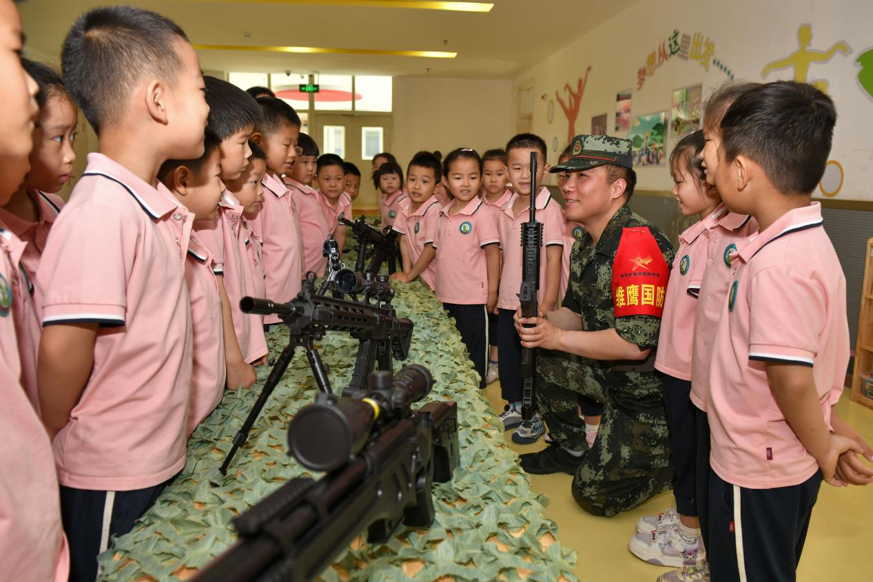 5月20日，在鄒平市全民國防教育進校園活動中，工作人員為黃山實驗幼兒園幼兒講解槍械知識。