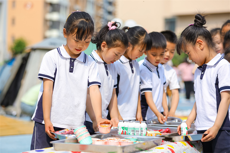 2025年5月26日，小朋友在山東省青島市李滄區(qū)青山路幼兒園開展迎“六一”主題活動中選取美食。張鷹 攝