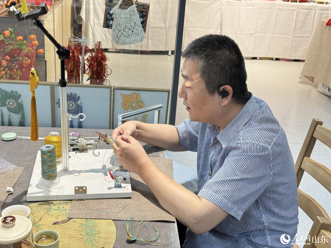 手藝人正在通過(guò)精湛的技藝?yán)K編出蓮花瓣的弧度。人民網(wǎng) 莊潤(rùn)澤攝