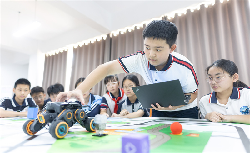 7月12日，在山東省臨沂第十中學(xué)，學(xué)生正在進(jìn)行輪式機(jī)器調(diào)試。